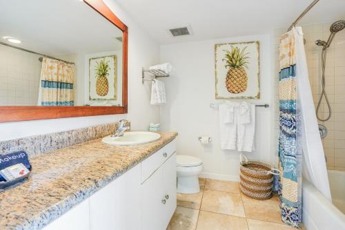 a bathroom with a sink and a toilet and a mirror at "Slice of Paradise" Oceanfront Studio at Islander on the Beach 225 in Kapaa