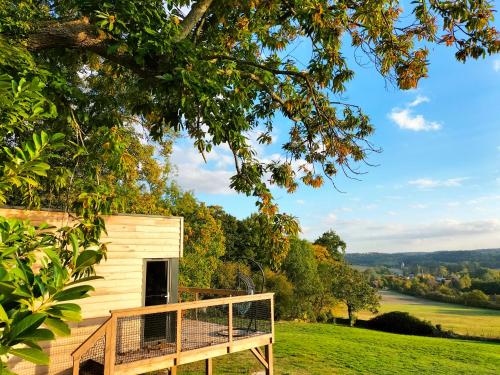 a cabin with a deck and a tree at Demeure de la Garenne in Montmirail
