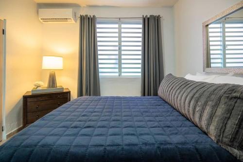 Un dormitorio con una cama azul y una ventana en 1 Santurce 1 Bedroom 1Bathroom Apt en San Juan