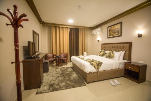 una camera d'albergo con letto e TV di Grape Village Hotel ad Amman