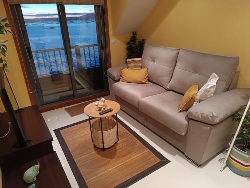 sala de estar con sofá y mesa en Mirador Mar de Castelao, 1ª línea de playa urbana, en Villanueva de Arosa