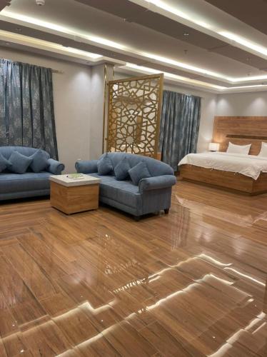 uma sala de estar com uma cama e um sofá em درة اجنادين للشقق المخدومة em Tabuk