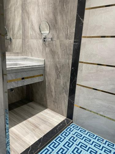 uma casa de banho com um chuveiro e um lavatório. em درة اجنادين للشقق المخدومة em Tabuk