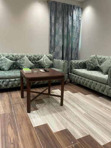 a living room with a couch and a coffee table at درة اجنادين للشقق المخدومة in Tabuk