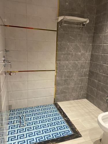 a bathroom with a shower and a toilet at درة اجنادين للشقق المخدومة in Tabuk