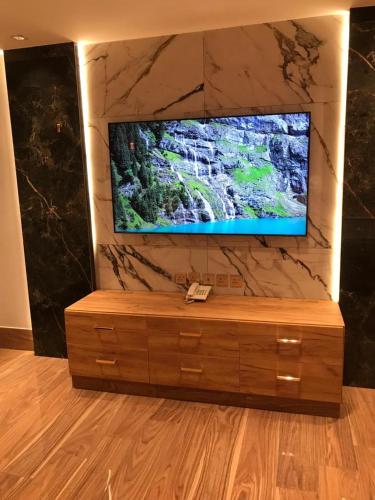 a flat screen tv sitting on a stone wall at درة اجنادين للشقق المخدومة in Tabuk