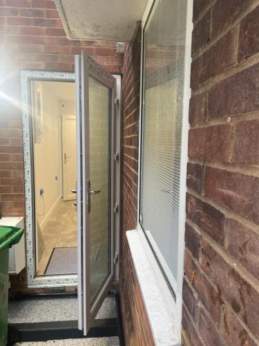 a door to a brick wall with a window at Skylight Deluxe Apartment with free parking, close to Windsor, Legoland and Heathrow in Farnham Royal