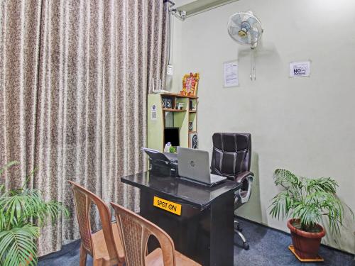een bureau met een laptop bij OYO Hotel G.K Lodging and Guest House in Sakardarā