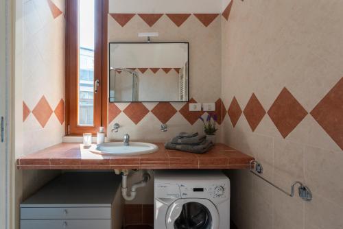 a bathroom with a sink and a washing machine at Sweet home Suite - Duomo, Milano in Milan