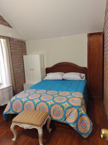 Schlafzimmer mit einem Bett mit blauer Decke in der Unterkunft House garden airport in Zamacola