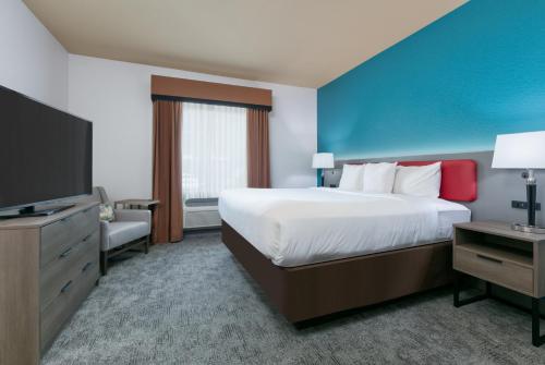 a hotel room with a large bed and a flat screen tv at Comfort Suites Arlington - Entertainment District in Arlington
