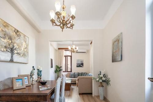a dining room and living room with a chandelier at Casa Di Sofia in Rethymno Town