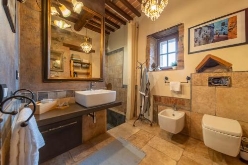 a bathroom with a sink and a toilet and a mirror at Enchanted Hideaway in Murlo