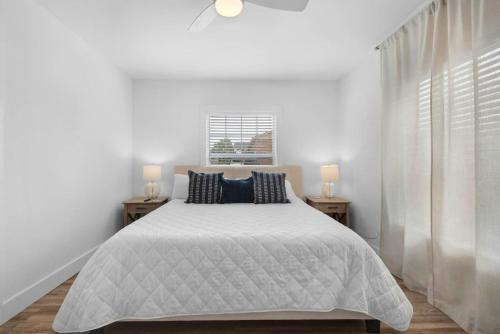 a white bedroom with a large bed with two night stands at Bluefish 2 Okaloosa Island Walk2Beach 2BR in Fort Walton Beach