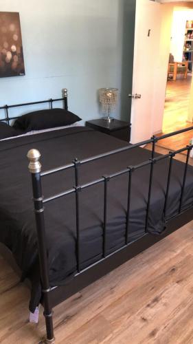 a bed with a black bed frame on a wooden floor at Los Angeles Zen Home in Los Angeles