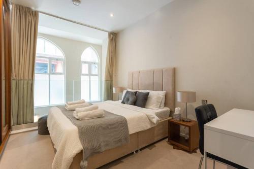 een slaapkamer met een groot bed met kussens erop bij Luxury 2 bedroom flat in Holborn in Londen
