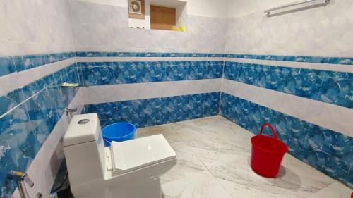 baño con paredes de azulejos azules y blancos y aseo en Paradise Resort Vattavada, Munnar en Vattavada