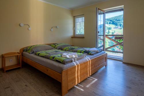 a large bed in a room with a large window at Apartmány Penzion Koula in Pec pod Sněžkou