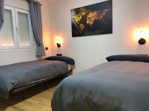 a room with two beds and a picture on the wall at Sierra Nevada Galatino 22E in Sierra Nevada