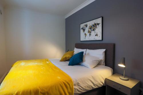 een slaapkamer met een groot bed met gele lakens en kussens bij The best flat on the street - Three minutes walk from the beach in Southend-on-Sea