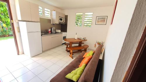 ein Wohnzimmer mit einem Sofa und einer Küche in der Unterkunft Eden Part' - Appartement avec jardin privé à Baie-Mahault in Baie-Mahault