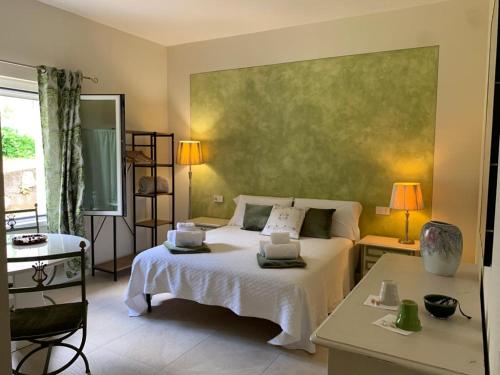 a bedroom with a white bed and a green wall at Villa Marta bed and breakfast in Gussago