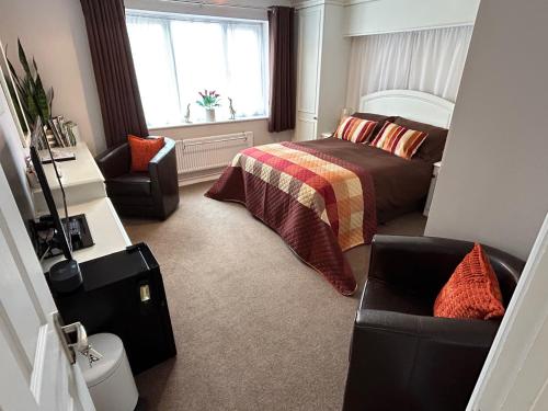 um quarto com uma cama, uma cadeira e uma janela em Puck's Retreat Bed & Breakfast em Tredington
