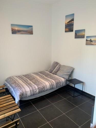 Ce lit se trouve dans un dortoir doté d'une table et de photos murales. dans l'établissement Belle maisonnette au cœur de Nancy centre, à Nancy