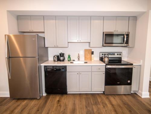 eine Küche mit weißen Schränken und Geräten aus Edelstahl in der Unterkunft The Josi:Elegant space and view in Washington