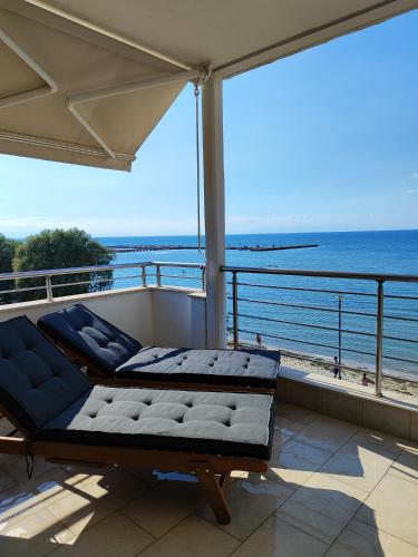 a balcony with a couch and a view of the ocean at Vista mare by Oikies Rentals in Neoi Epivates
