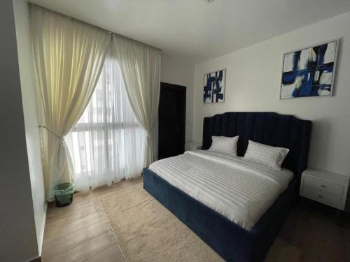 a bedroom with a bed and a large window at The Vistana Eko Pearl Towers Apartment in Lagos