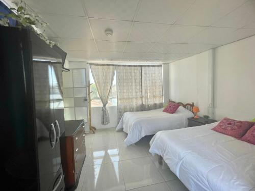 a hotel room with two beds and a window at Samadri in Arequipa