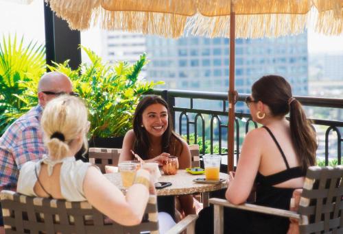 a group of people sitting at a table in a restaurant at Virgin Hotels New Orleans in New Orleans