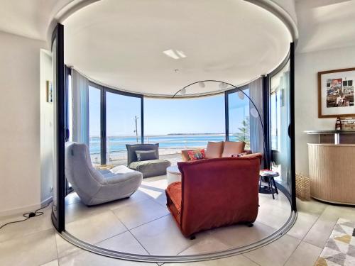 - un salon avec un cercle de verre au milieu dans l'établissement Vue sur mer La Baule Soléa, à La Baule
