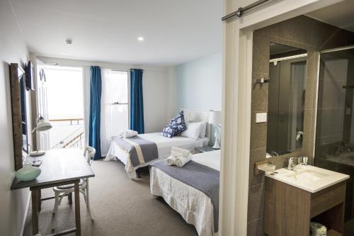 Habitación de hotel con 2 camas y lavamanos en Rambutan Resort en Townsville