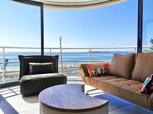 un salon avec un canapé et une table dans l'établissement Vue sur mer La Baule Soléa, à La Baule