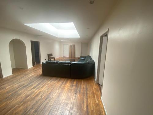 a living room with a black leather couch in a room at Los Angeles Zen Home in Los Angeles