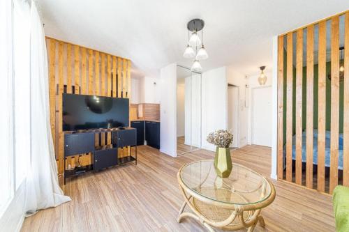 un salon avec une table en verre et une télévision dans l'établissement Studio with semi-open bedroom Near Part-Dieu & Tram, à Lyon