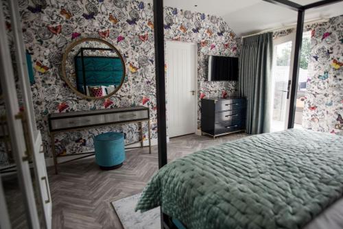 a bedroom with a bed and a mirror and a dresser at Dewars Restaurant and Rooms in Malton