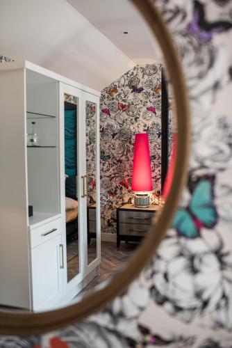 a room with a red lamp in a mirror at Dewars Restaurant and Rooms in Malton