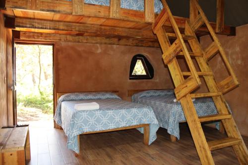 a bedroom with two beds and a ladder at La Montaña Parque Natural 