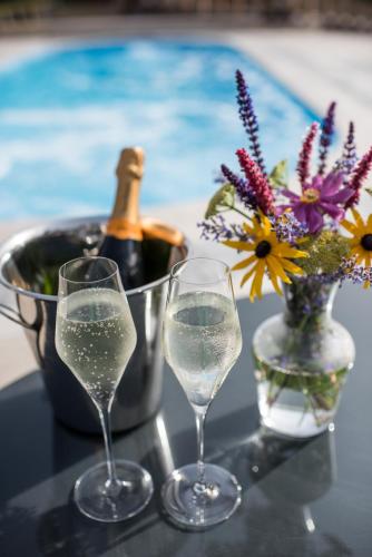 two glasses of champagne and a vase of flowers on a table at Dewars Restaurant and Rooms in Malton