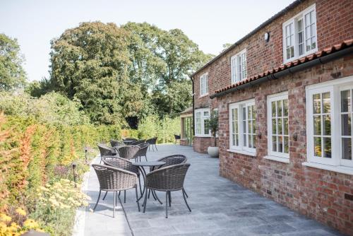 a patio with tables and chairs next to a brick building at Dewars Restaurant and Rooms in Malton