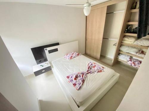 een witte kamer met een bed met een stropdas erop bij Hermoso apartamento in Ricaurte