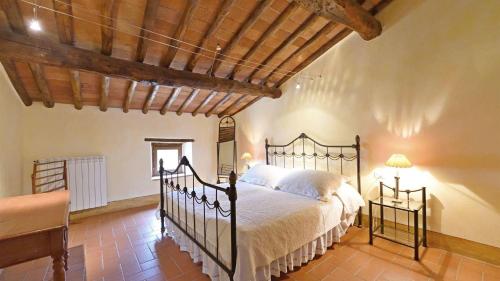 sypialnia z łóżkiem i drewnianym sufitem w obiekcie Pergola w mieście Gaiole in Chianti