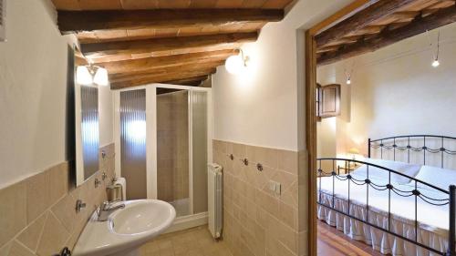łazienka z umywalką, prysznicem i łóżkiem w obiekcie Pergola w mieście Gaiole in Chianti