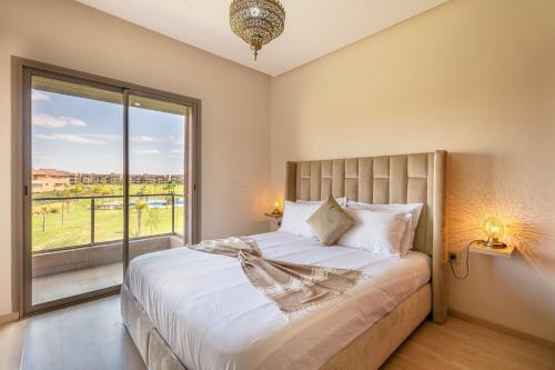 um quarto com uma cama e uma grande janela em Perle Rare a Prestigia - Vue Sur Golf em Marrakech
