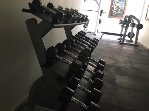a gym with a bench with dumbbells in it at The Vistana Eko Pearl Towers Apartment in Lagos