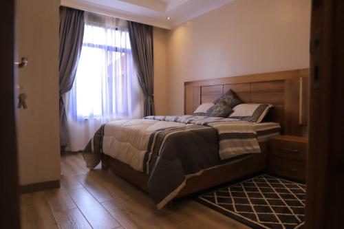 um quarto com uma cama grande e uma janela em Didy d’Or Lounge em Kigali