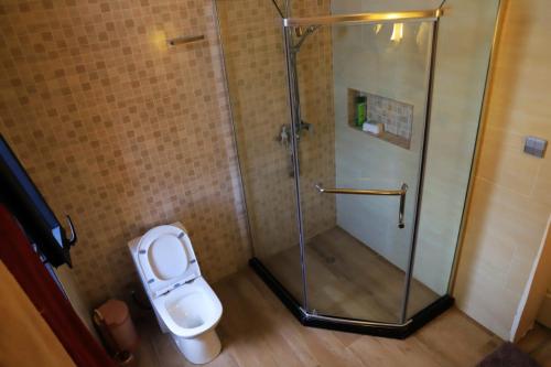 uma casa de banho com um chuveiro e um WC. em Didy d’Or Lounge em Kigali
